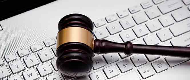 O que muda com a nova Lei de Licita&ccedil;&otilde;es? Na imagem, teclado de computador e martelo da justi&ccedil;a representando mudan&ccedil;as trazidas pela Lei 14.133/2021