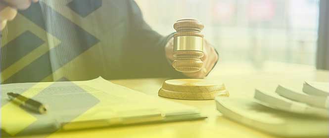 O que é BB licitações? Na imagem, pessoa batendo martelo da justiça em representação a processo de licitação finalizado 