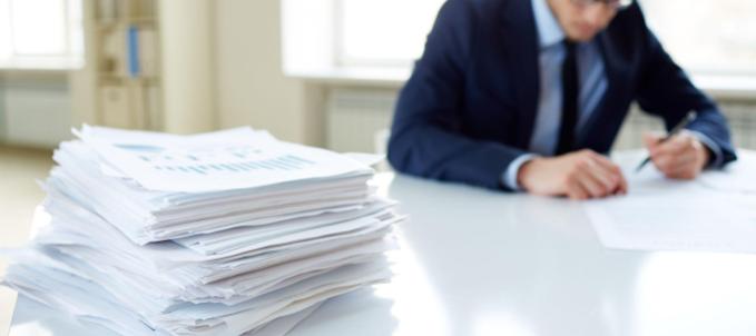 seguro garantia contrato administrativo: na imagem, microempreendedor lendo contrato, que será protegido por seguro garantia de contrato administrativo 