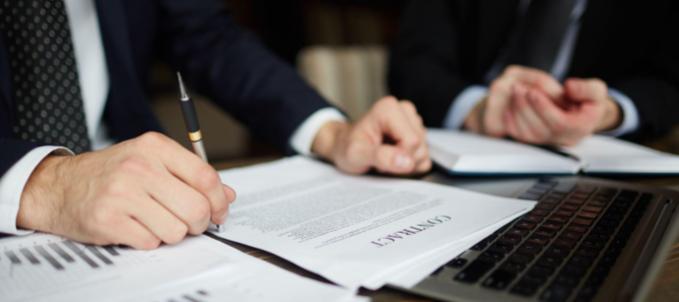 como-funciona-o-seguro-garantia Como funciona o seguro garantia? Na imagem, dono de empresa assinando contrato de seguro garantia após ser contemplado em processo de licitação pública